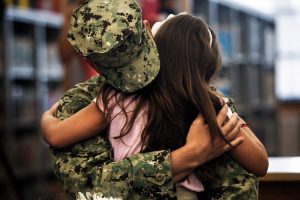 U.S. Navy petty officer first class Johnny Padron wraps his arms around his daughter Melanie Padron, 7, after he surprised her while she was in the library with her fellow first graders at Vineyards Elementary on Monday May 19, 2014. Padron has been in Bahrain for the past 12 months until he arrived home on Sunday. Padron said it was tough to keep the secret from his daughter and it was also tough when he saw her on Monday. "I was choked up when I saw her, I couldn't get a breath out," said Padron. "They say that we (military) sacrifice, but they sacrifice a lot too." (Scott McIntyre/Staff)