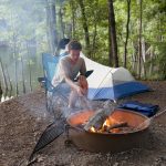 teenager camping with camp fire