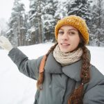Young female travel blogger giving tour in winter forest