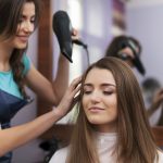 Hair stylist drying woman’s hair