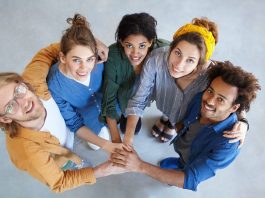 Friendly people of different races looking from above holding their hands together embracing each ot