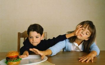 Siblings Fighting over Hamburger --- Image by © Anthony Redpath/Corbis