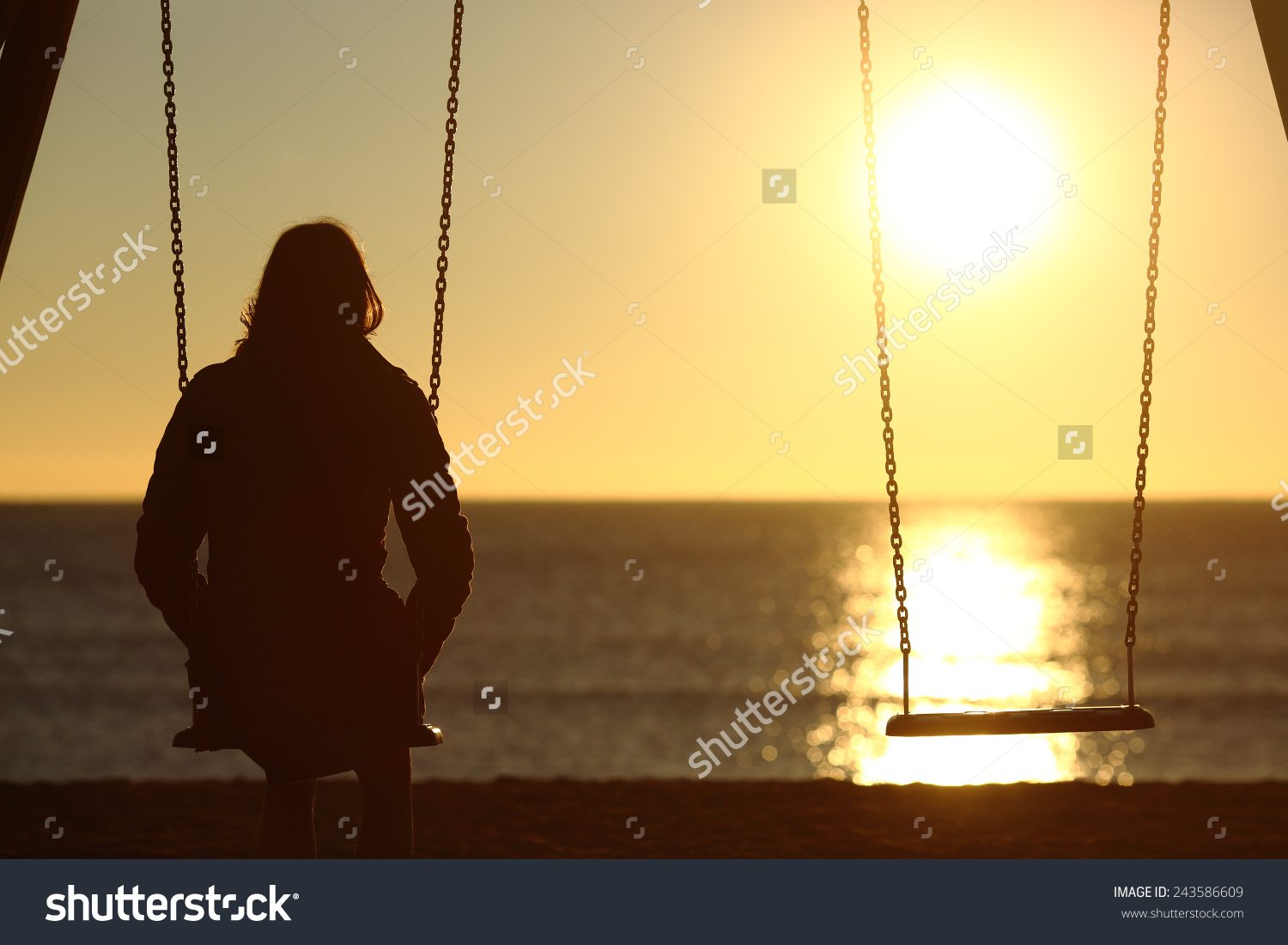stock photo lonely woman watching sunset alone in winter on the beach at sunset