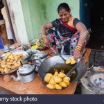 india-uttar-pradesh-varanasi-a-woman-cooking-fried-pakora-and-samosas-at-a-food-hotel-MPCGGH