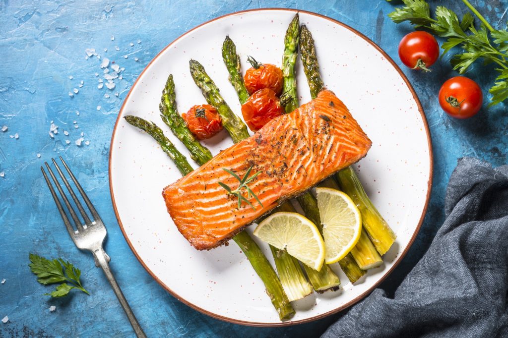 Grilled salmon fish with asparagus and tomato.