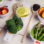 Portion cups and spoons of healthy ingredients on wooden table