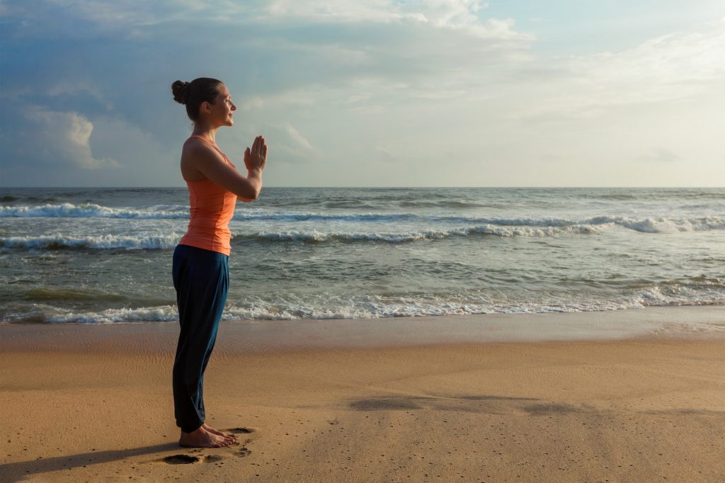 Woman doing yoga on beach