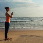 Woman doing yoga on beach