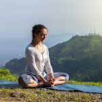 Woman practice yoga asana Baddha Konasana outdoors