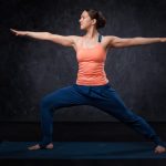 Woman practices yoga asana utthita Virabhadrasana