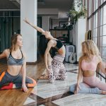 Young attractive women practicing yoga near window