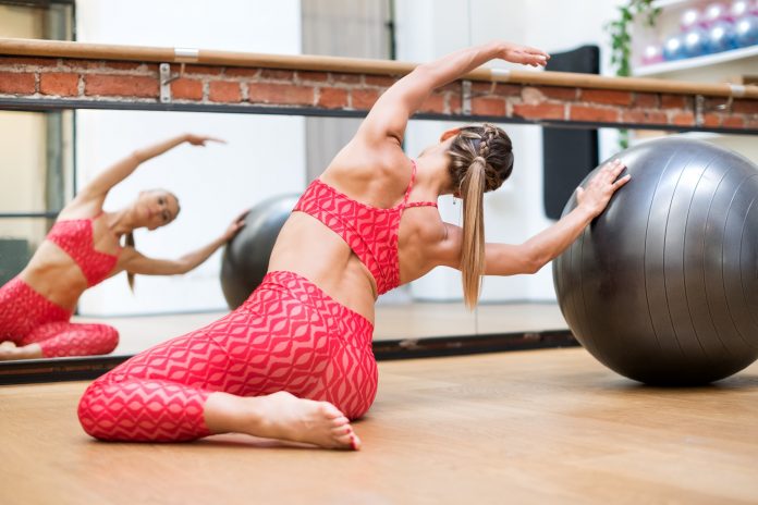 Young woman doing pilates mermaid exercises