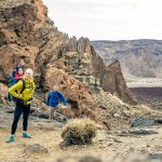 Family hiking with baby boy travelling in backpack