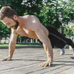 Fit fitness man doing fitness exercises outdoors at city