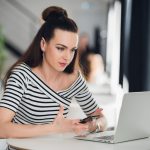 Puzzled woman writer working on a new idea for her book. Adult attractive woman sitting at the table