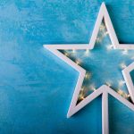 White Christmas star with yellow lights on blue background