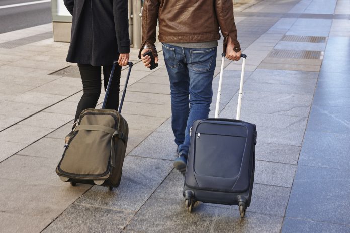 Young couple with baggage on the street. Travel and tourism