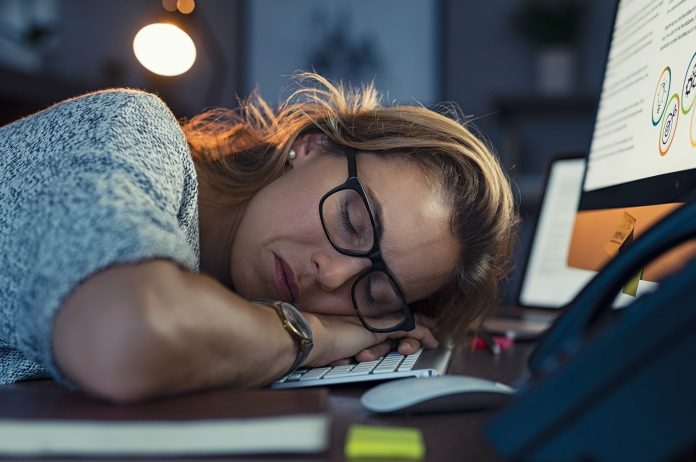 Business woman sleeping on computer at night