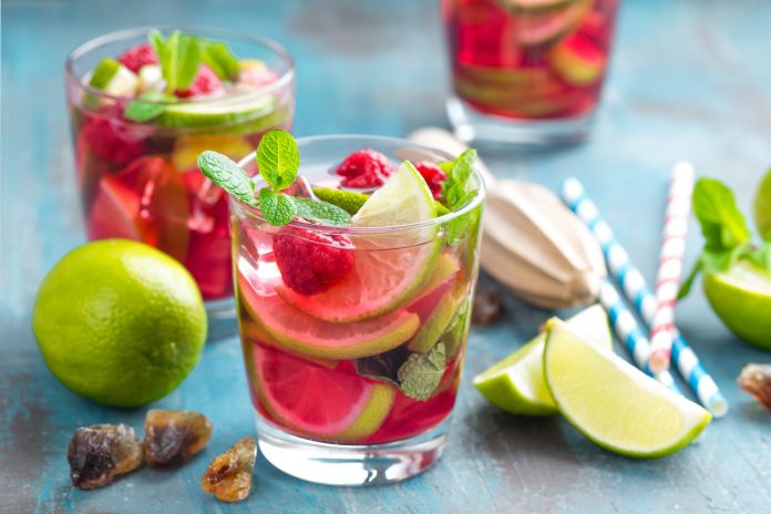 Refreshing mint cocktail mojito with rum, lime and raspberry, cold drink or beverage