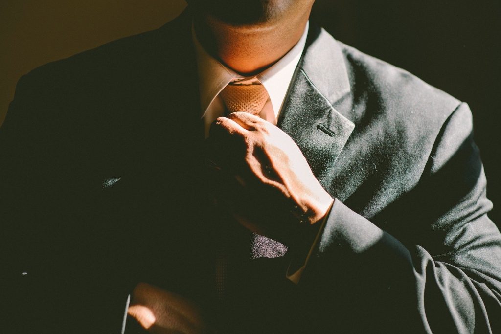 Adjusting necktie in suit, building confidence.