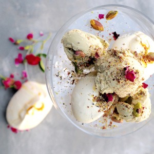cashew rose ice cream garnished with some chopped pistachios and dried rose petals