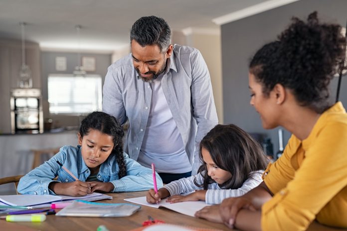 Mixed race parents helping children in homework at home