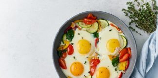 Fried eggs poached with vegetables on teflon pan, Keto meal, FODMAP recipe