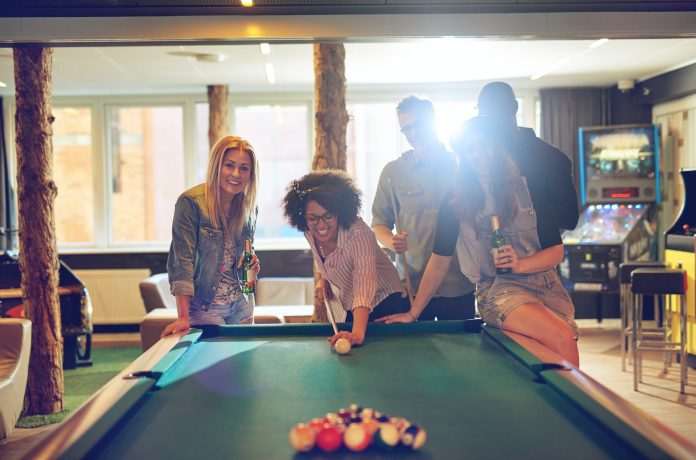 Friends in game room playing pool