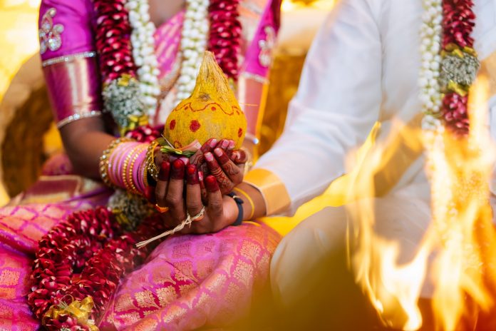 Indian Hindu Traditional Wedding Ceremony - Close up shot of the couple hand holding the decorative