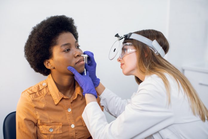 Young afro american lady patient at modern ENT clinic. Professional female doctor