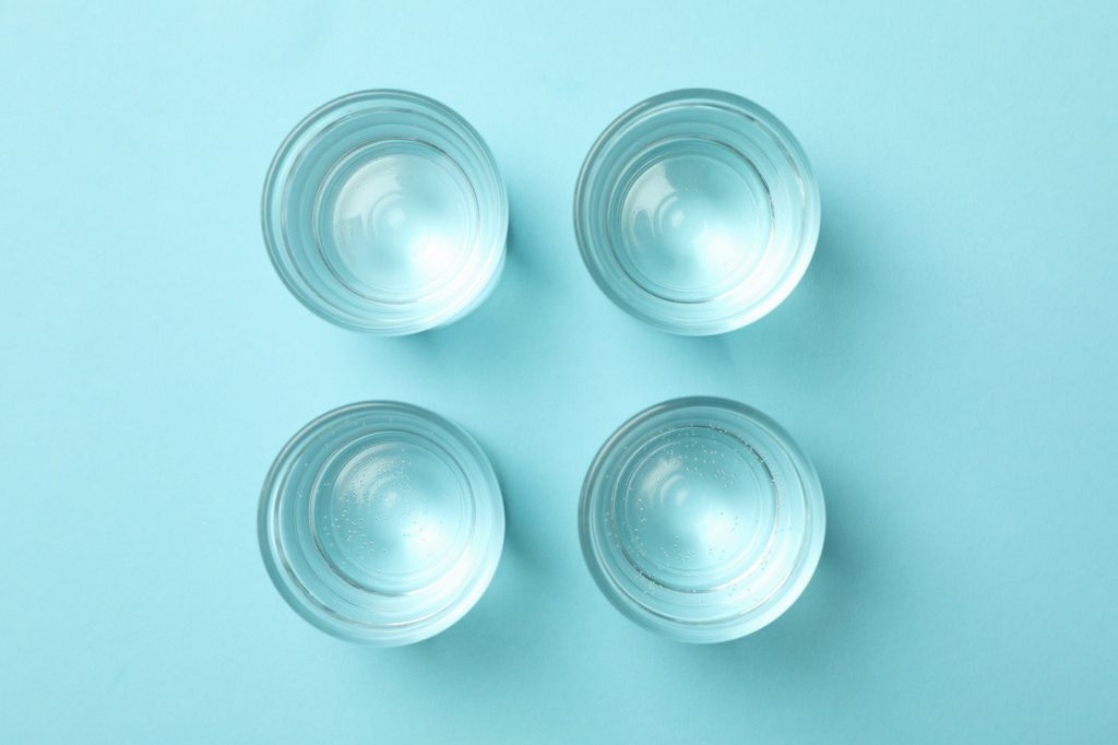 Full shots or glasses on blue background, top view