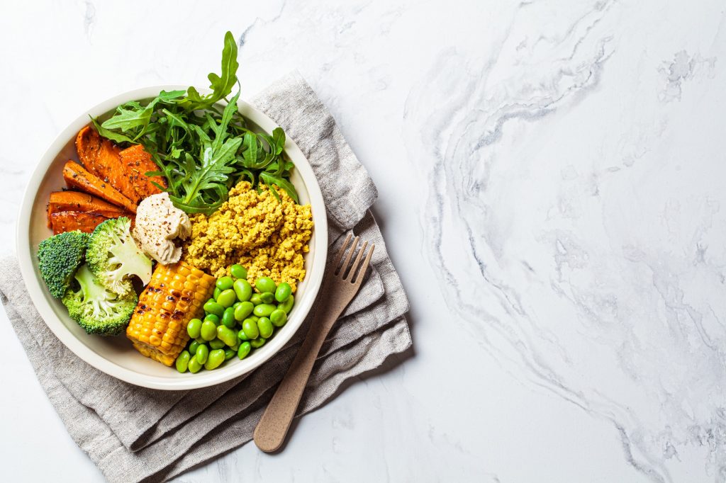 scrambled tofu, corn, beans, sweet potato and broccoli. Plant-based diet concept.