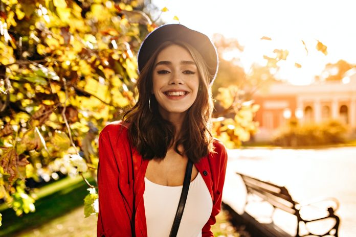 Gorgeous young girl with medium dark hair, white top, red shirt and beret, smiling and posing looki