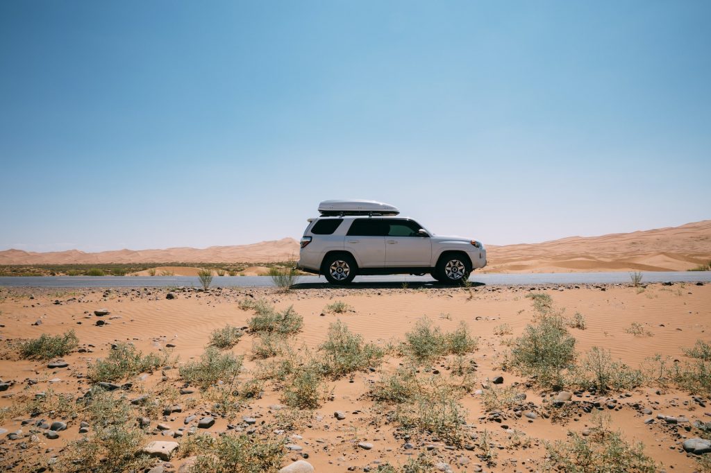 Driving White 2020 Toyota 4Runner TRD crossing in the desert road trip