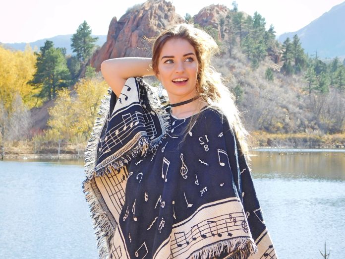 Beautiful Young Woman Wearing a Fashionable Poncho at a Mountain Lake during Autumn