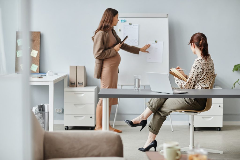 Pregnant businesswoman working at conference