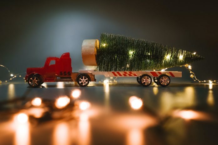 Red car with christmas tree on trailer.