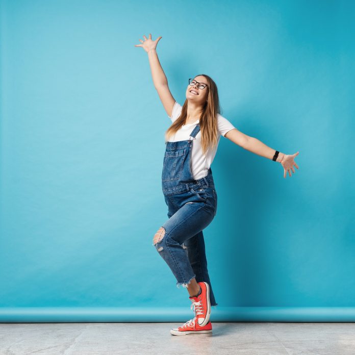 The world is mine concept - happy pregnant woman on blue background