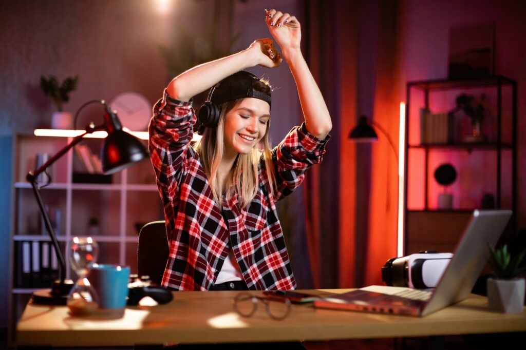 Portrait of a beautiful young blonde woman dressed in casual shirt, listening musing with headphones