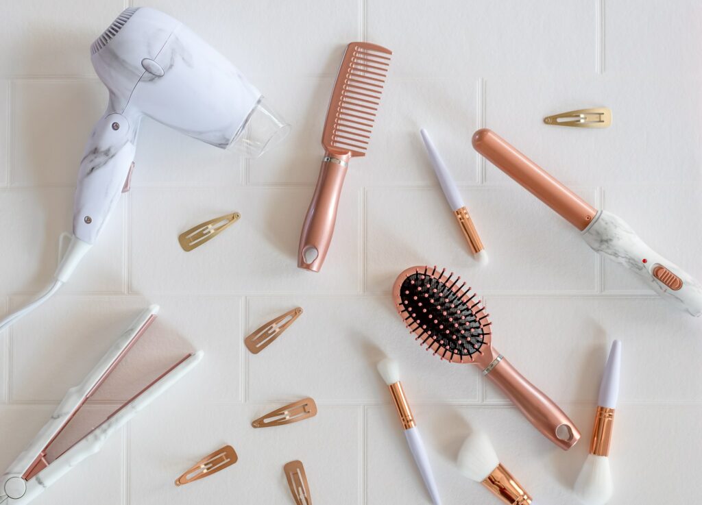 Beautiful modern rose gold hair styling products on a white background