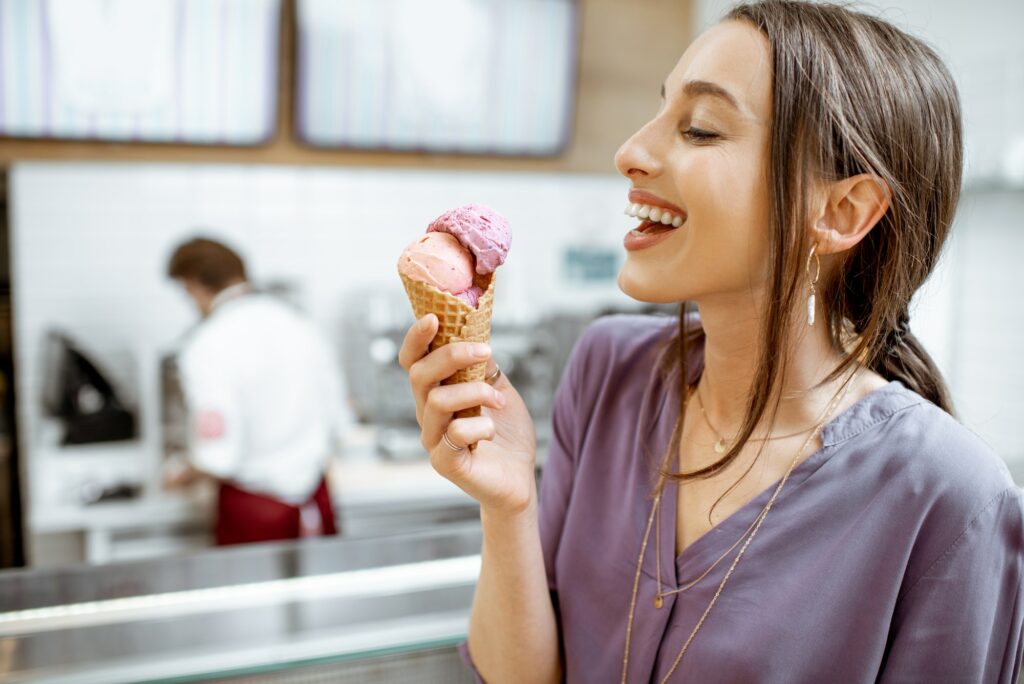 Happy woman with ice cream in the shop