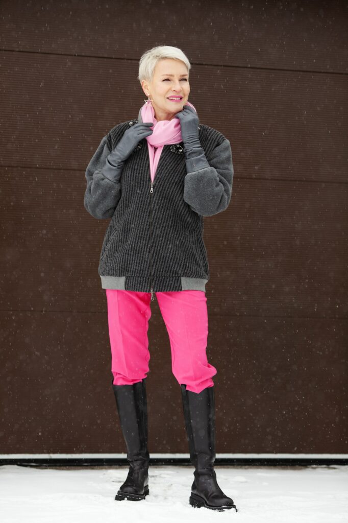 woman winter outfit with high boots, pink pants, bomber jacket