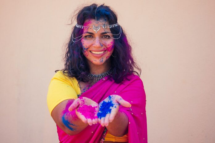 female indian model snow-white smile on holi color festival.