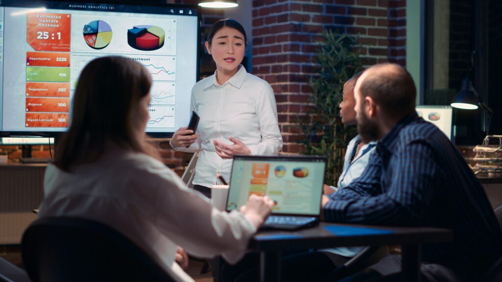 Asian businesswomen giving analytics research presentation in business meeting