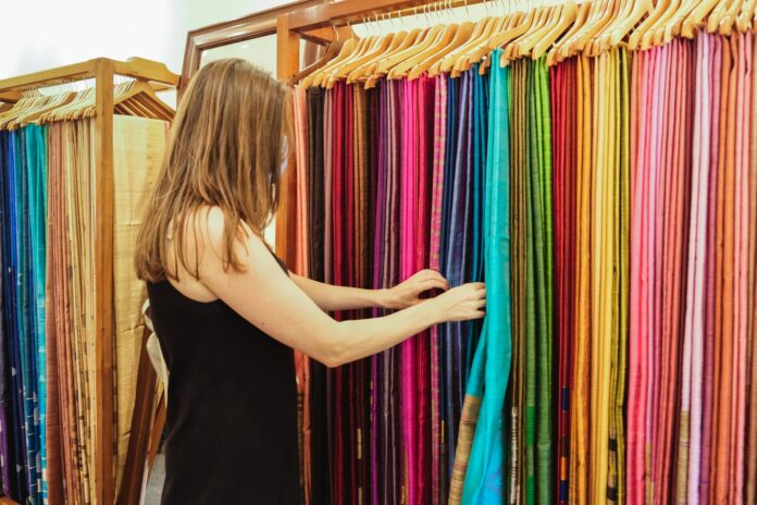 A woman examines fabrics at a fabric and sarong store in India