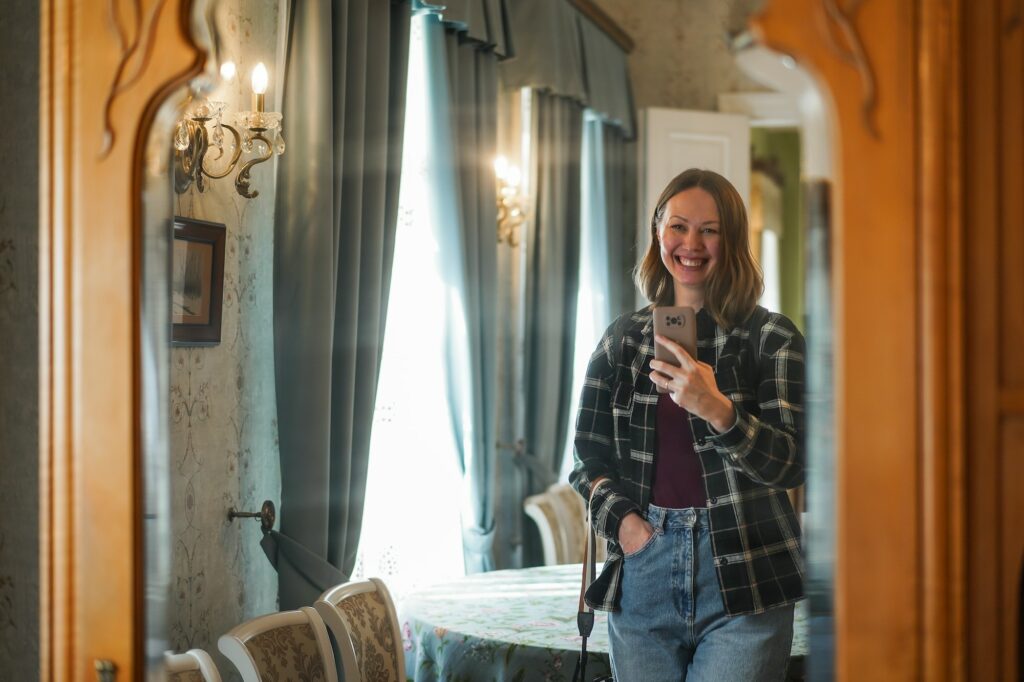 beautiful girl takes a selfie through an antique mirror