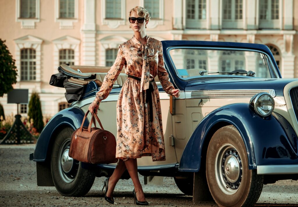 Beautiful lady with bag near classic convertible