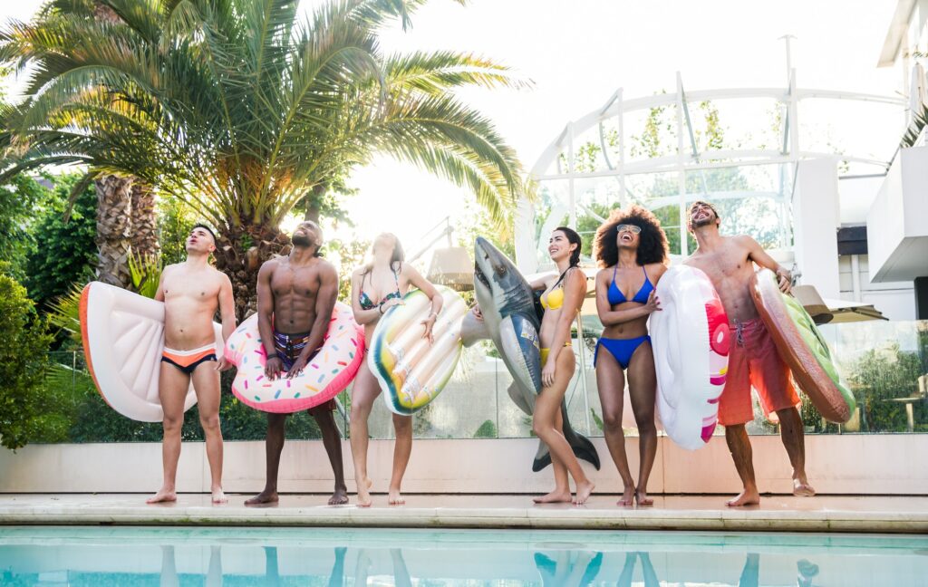 Group of happy friends having fun at pool party with swimwear.