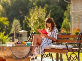 Woman reading a book in the backyard