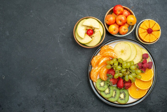 top view different fruits composition fresh and sliced fruits on a dark background fresh fruits